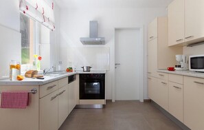 Enjoy cooking in this well-equipped kitchen with a stainless steel oven, microwave, and range hood.