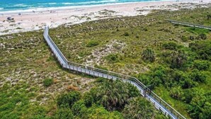 A coastal walkway with a view of the beach and ocean.