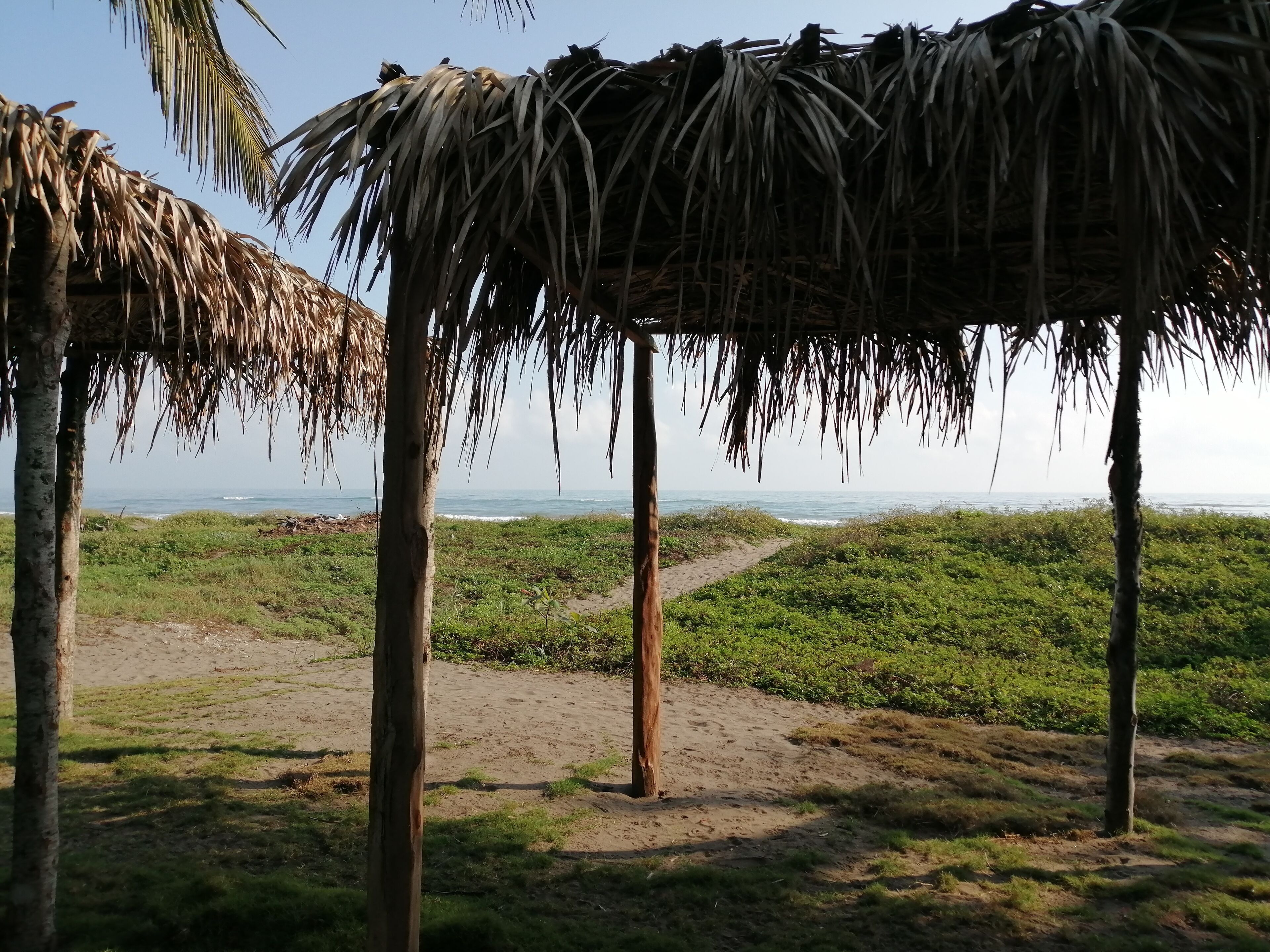 Una construcción de paja con vista al océano.