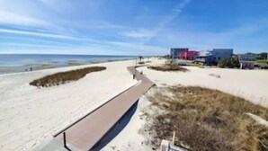 A beach with a pathway leading to buildings.
