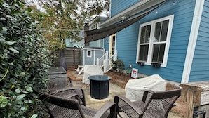 Un patio con mobiliario exterior, un cobertizo pequeño y una zona de estar techada.