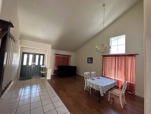 Relax in this inviting living area with a dining table, comfortable sofa, and chandelier.