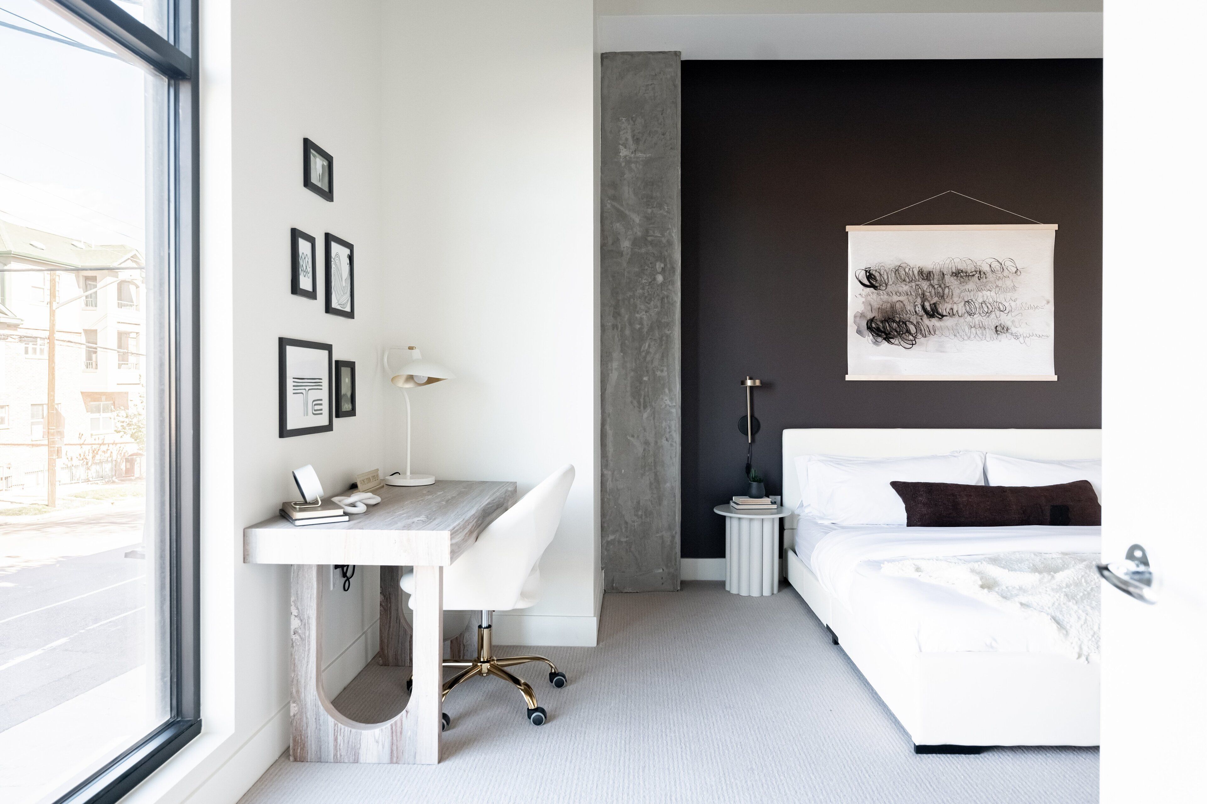Une chambre moderne avec un bureau, un lit et une vue sur la rue.