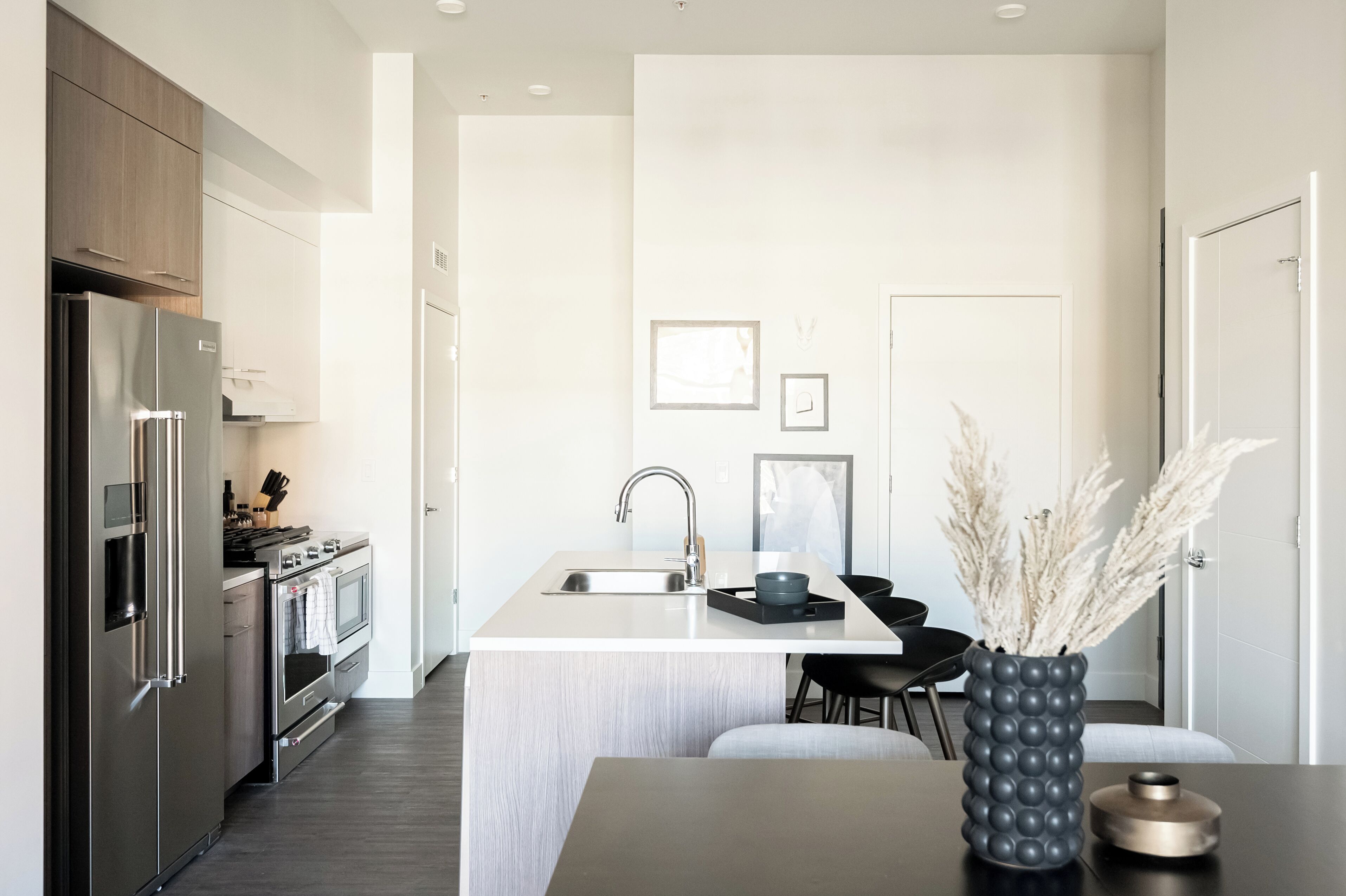 Una cocina moderna con una isla central, electrodomésticos de acero inoxidable y un diseño minimalista.
