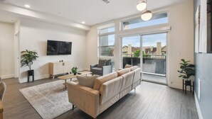 Un salon moderne avec un canapé, une table basse et un téléviseur fixé au mur.