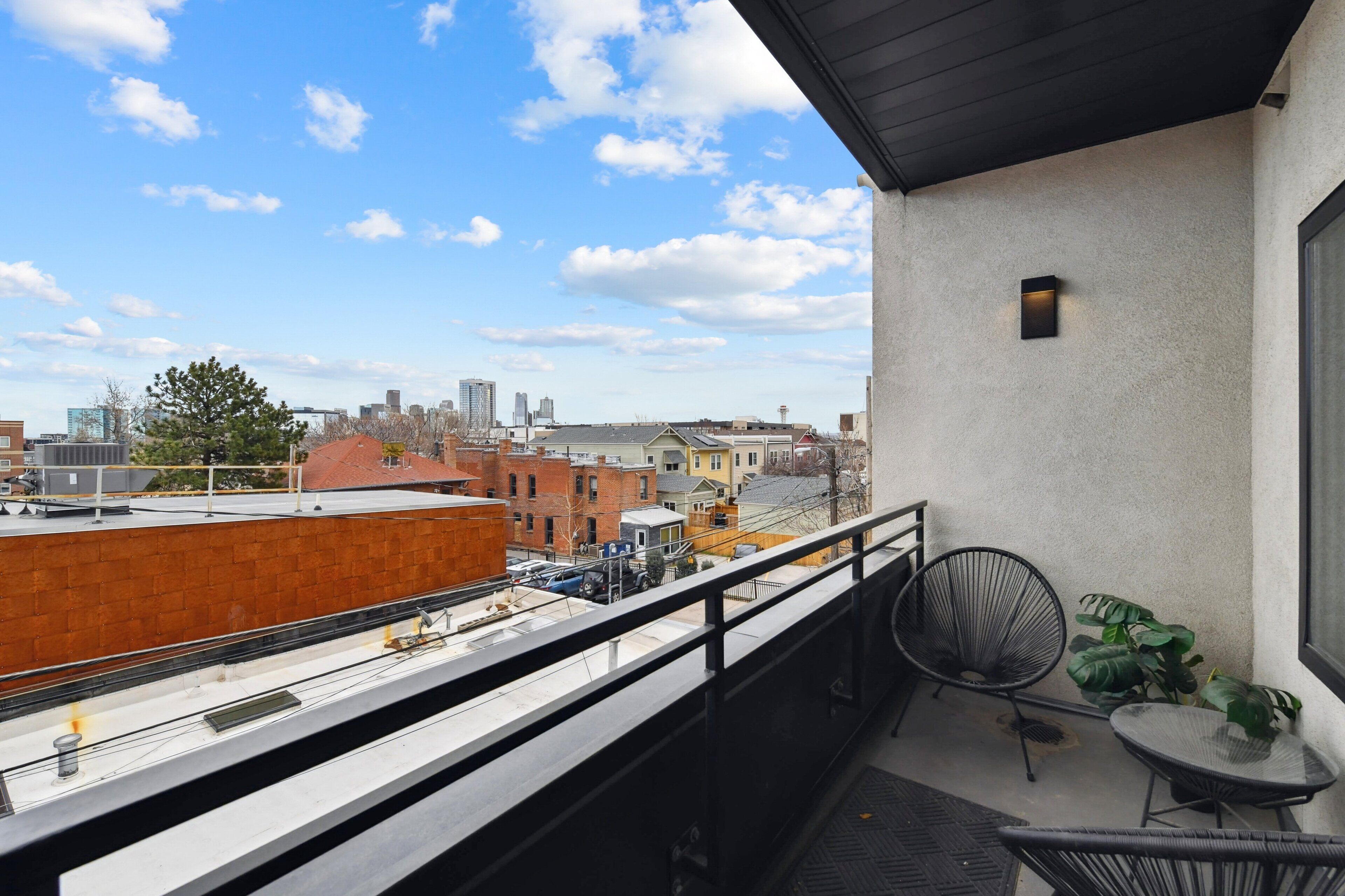 A balcony with a view of a cityscape, including buildings and a water tower.
