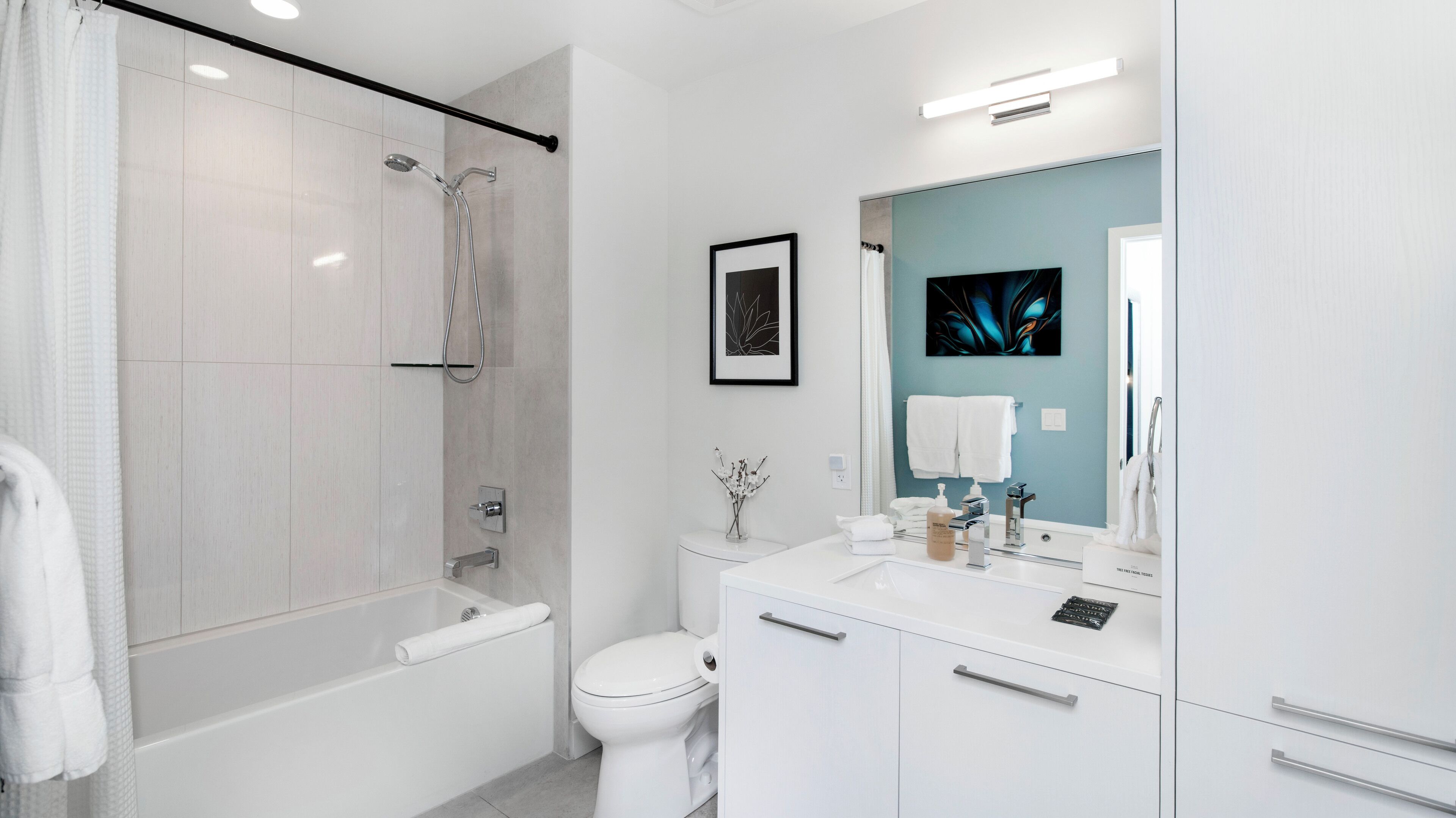 Un bagno moderno con cabina doccia, servizi igienici e una cassettiera con specchio.