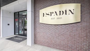A building entrance with a sign reading "ESPADIN EST 2021" and a door labeled "FACP".