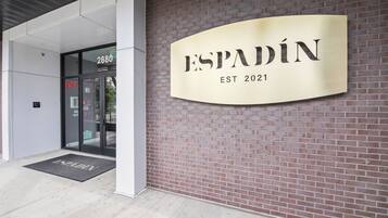 Entrada de un edificio con un letrero que dice "ESPADIN EST 2021" y una puerta identificada con "FACP".