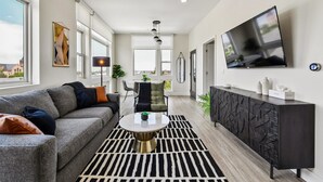 En moderne stue med sofa, sofabord og fjernsyn.