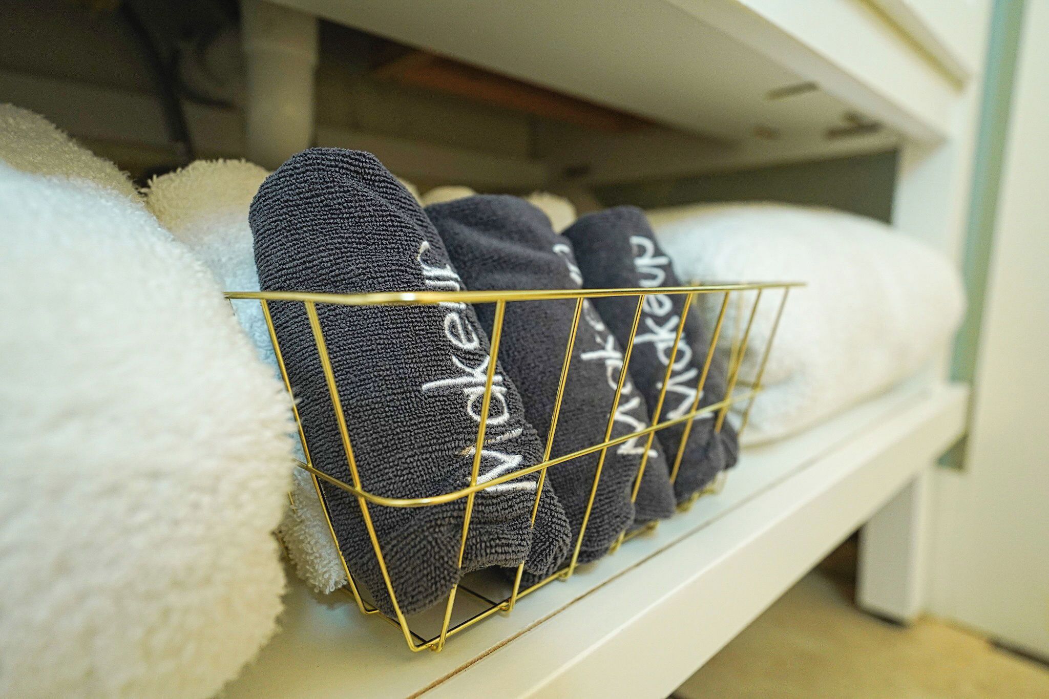 A storage shelf with neatly folded towels and socks.