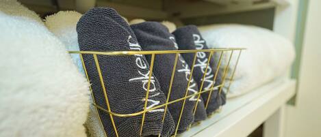 A storage shelf with neatly folded towels and socks.