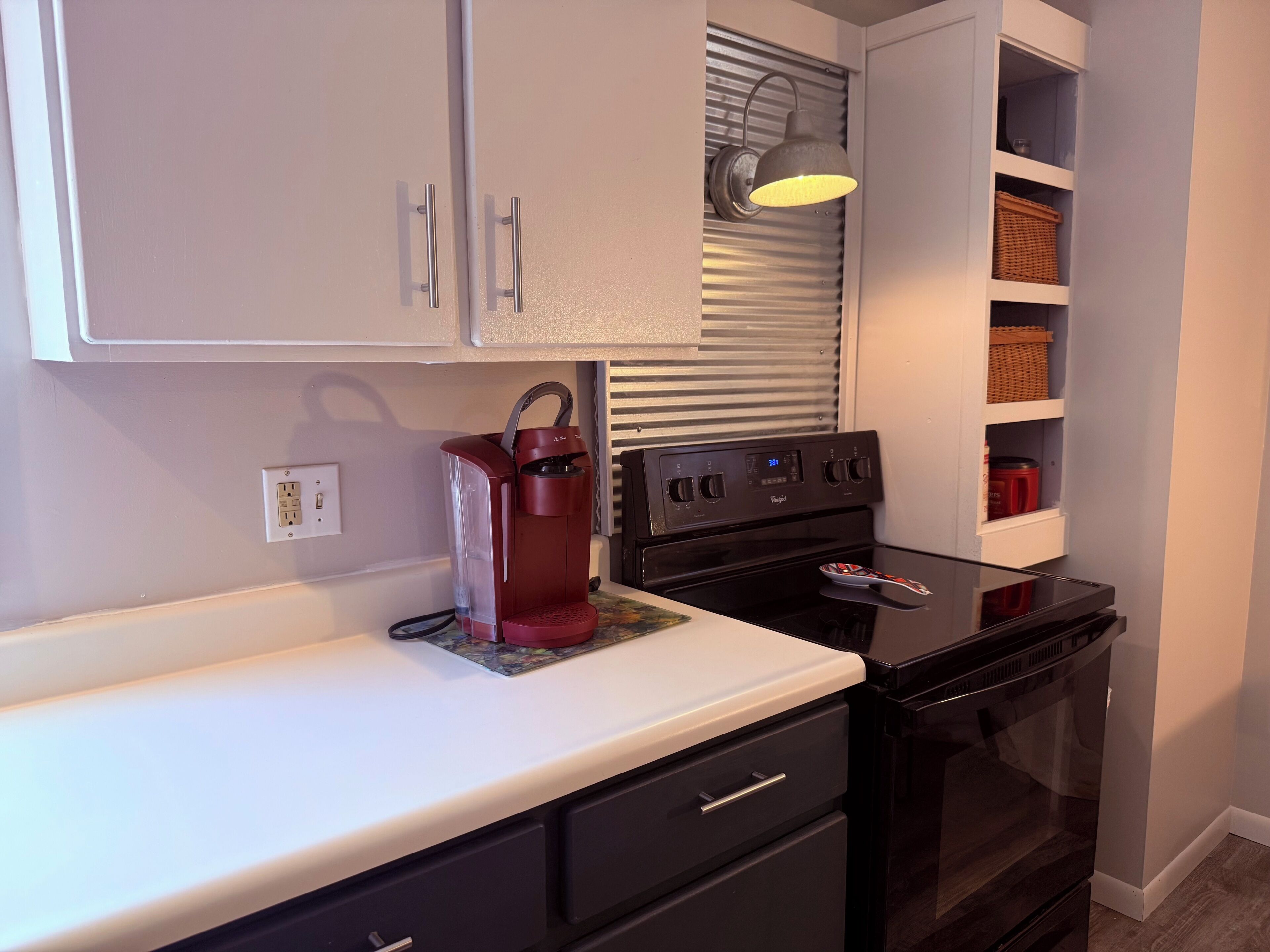 Una cocina equipada con cafetera, estufa y microondas.
