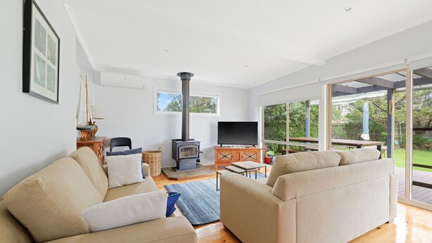 Uma sala de estar moderna com lareira, assentos confortáveis e uma grande janela com vista para o exterior.