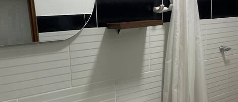 A bathroom with a white sink, toilet, and shower curtain.