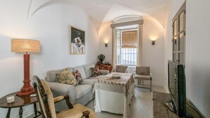 A living room with a sofa, armchairs, a coffee table, a lamp, a TV, and a window with blinds. - Awesome home in Carmona (Carmona)