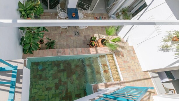 A rooftop pool area with potted plants, a seating area with a table and chairs, and a blue staircase. - Awesome home in Carmona (Carmona)