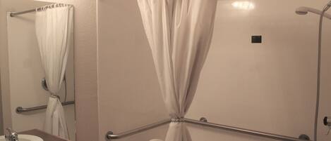 A bathroom with a white sink, mirror, and shower curtain.