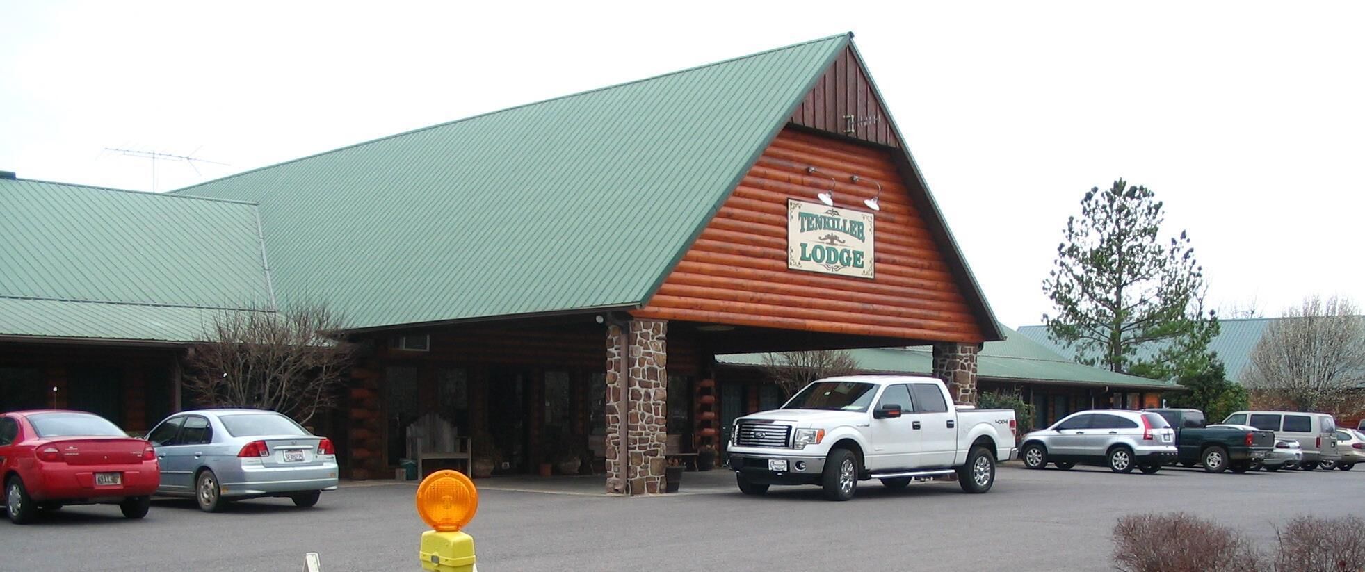 A lodge with a green roof and a sign that reads "Ten Killer Lodge."