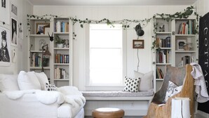 A cozy room with a white sofa, a wooden bench, and a bookshelf filled with books. - Dreamy Mountain View Cottage + Creative Work Space (Methow)