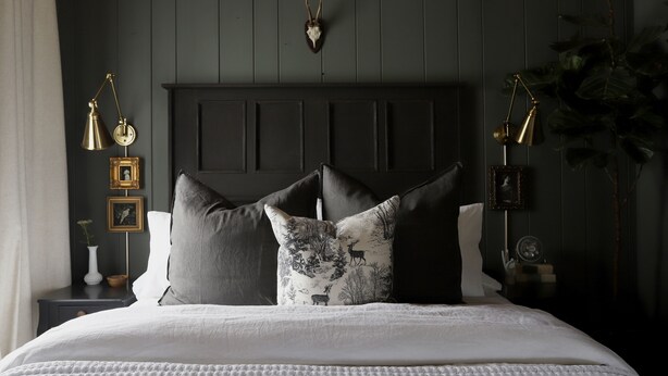 A bedroom with a dark wooden headboard, a white bedspread, and two bedside lamps. - Dreamy Mountain View Cottage + Creative Work Space (Methow)