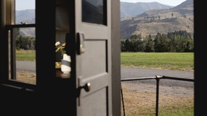A view through a door with a metal gate, leading to a grassy field and distant hills. - Dreamy Mountain View Cottage + Creative Work Space (Methow)