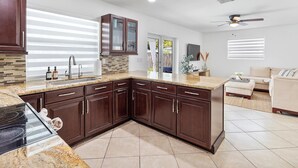 Una cocina moderna con armarios de madera oscura, encimera de granito y estufa empotrada.
