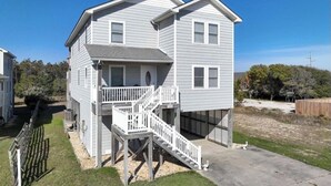 A two-story house with a front porch and a small deck. - Beachside Breeze! 5 BR 3 BA beach paradise!  (Nags Head)