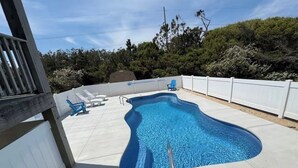 A swimming pool with a white fence, lounge chairs, and a wooden deck. - Beachside Breeze! 5 BR 3 BA beach paradise!  (Nags Head)