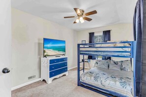 Cozy bedroom with a bunk bed, flat-screen TV, and ceiling fan.