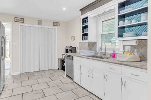 Enjoy cooking in this well-equipped kitchen with a dishwasher, sink, and ample countertop space.