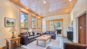 A spacious living room with a high ceiling, large windows, and a fireplace. - Mountain Retreat with Deck and Hot Tub (Blue River)