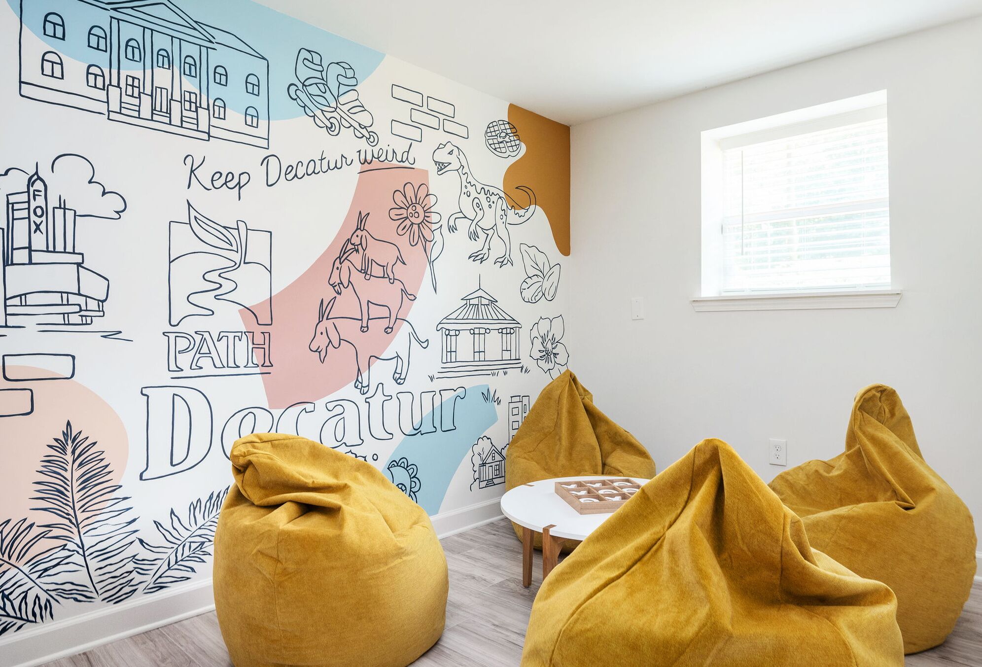 A room with a mural, bean bags, and a small table.