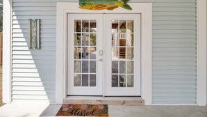 A house with a double door, a welcome sign, and a fish-shaped sign above the door.