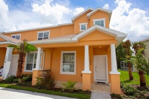 A two-story house with a front porch, a garage, and a well-maintained lawn. - Serene Villa with Private Pool (Clermont)