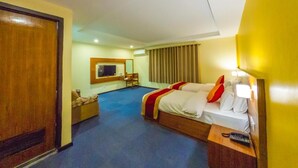 A hotel room with two beds, a TV, a desk, and a chair. - Hotel Ananda Pashupati  (Kathmandu)