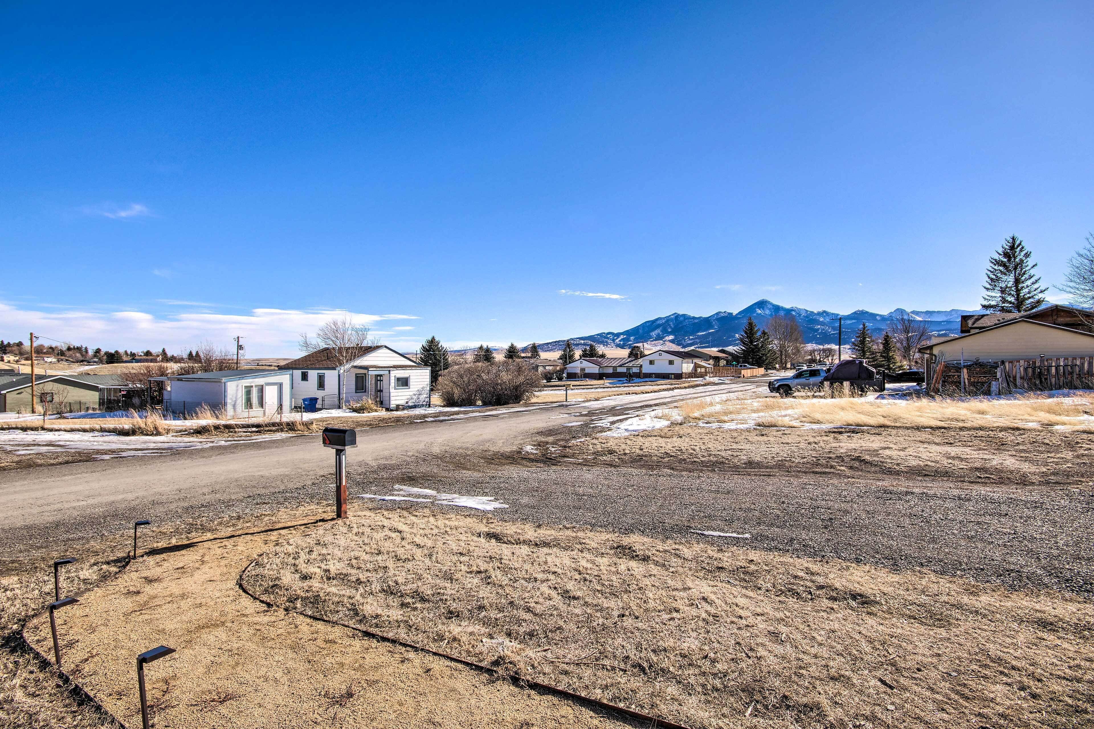 A rural road with houses and mountains in the background.
