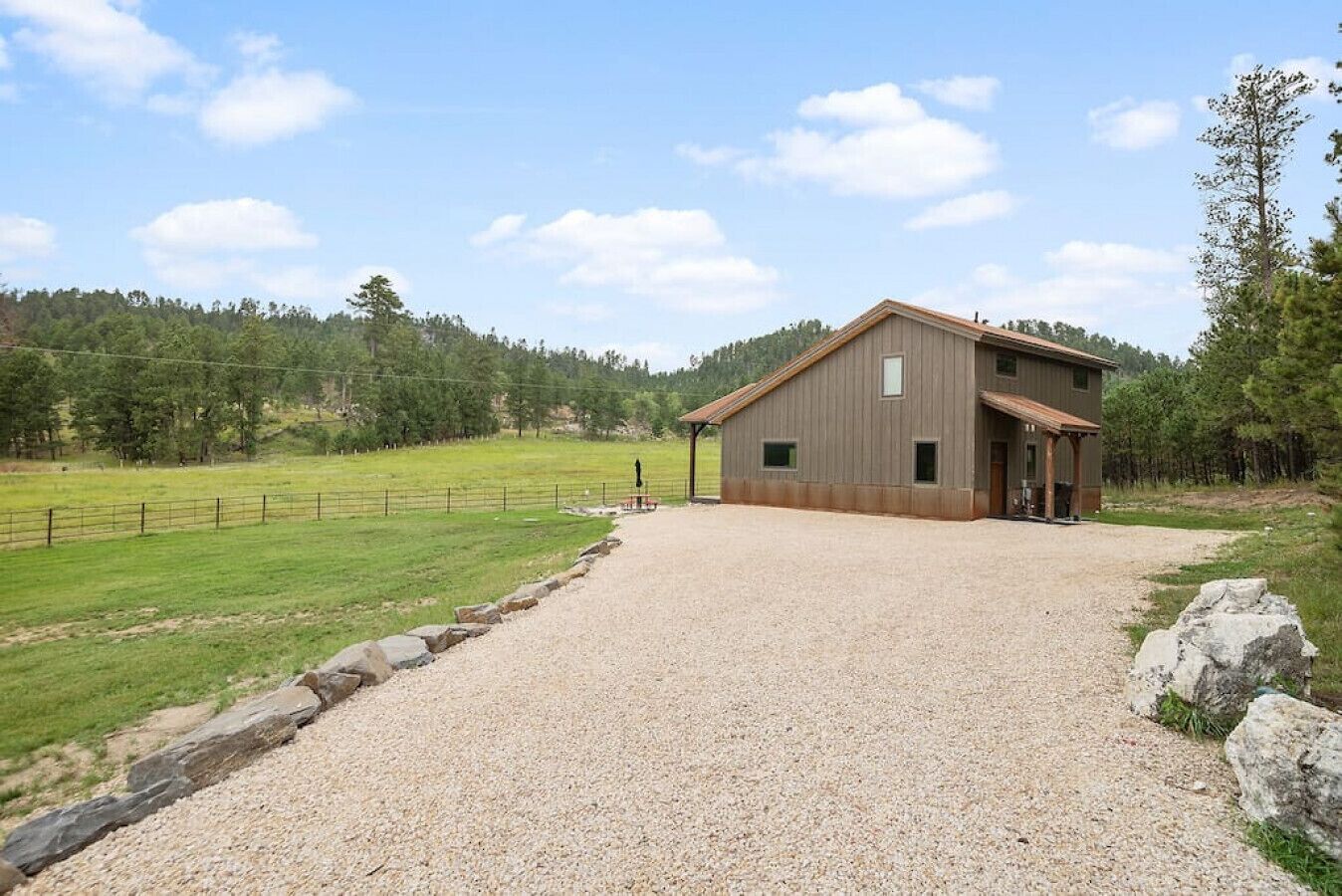 Un bâtiment d’un seul étage, avec une allée en gravier menant à une porte en bois.