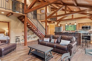 A spacious living area with a leather sofa, a coffee table, and a staircase leading to an upper level. - Hot Shot Hideaway near Custer Attractions (Custer)