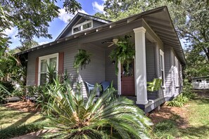 A house with a porch, potted plants, and a small garden. - Historic Moss Point House w/ Loft - 6 Mi to Beach! (Moss Point)