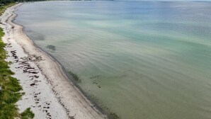 Een kuststrand met helder water en een zandstrand.
