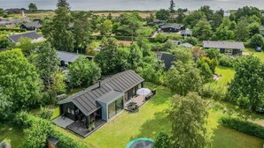 Een woonwijk met huizen, omringd door groen en een waterpartij op de achtergrond.