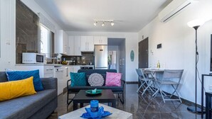 A modern living room with a sofa, coffee table, and dining area. - Kmeidos 1-Bedroom Apartment & Balcony in Larnaca (Cyprus - Larnaca)