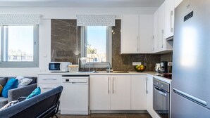 A modern kitchen with white cabinets, a built-in oven, and a stainless steel refrigerator. - Kmeidos 1-Bedroom Apartment & Balcony in Larnaca (Cyprus - Larnaca)