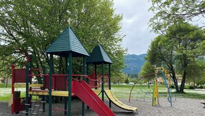 A playground with slides and climbing structures, surrounded by trees and a view of mountains. - Logement 2 Chambres, Entièrement Rénové, Dans Résidence Avec Piscine (Montbrun-les-Bains)