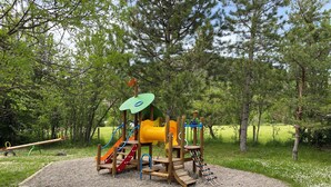 A playground with a slide, climbing net, and seesaw. - Logement 2 Chambres, Entièrement Rénové, Dans Résidence Avec Piscine (Montbrun-les-Bains)
