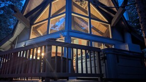 Eine Holzhütte mit großen Fenstern und einer Veranda.