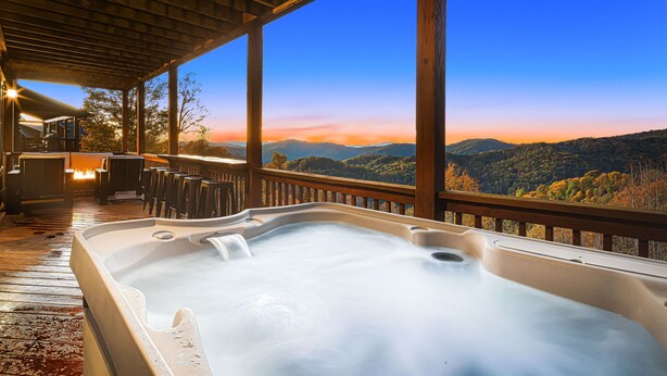 A hot tub with a wooden deck and large windows overlooking a mountainous landscape. - Steps from Hatley Pointe - Short drive to downtown Asheville! (Mars Hill)