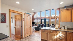 A spacious kitchen with wooden cabinets, a granite countertop, and a view of the mountains through large windows. - Steps from Hatley Pointe - Short drive to downtown Asheville! (Mars Hill)