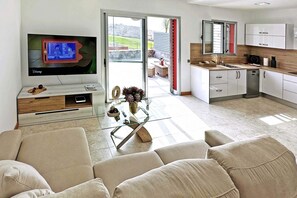 A modern living room with a flat-screen TV, a glass coffee table, and a sofa. - Salobre Vista Golf 8 (Maspalomas)
